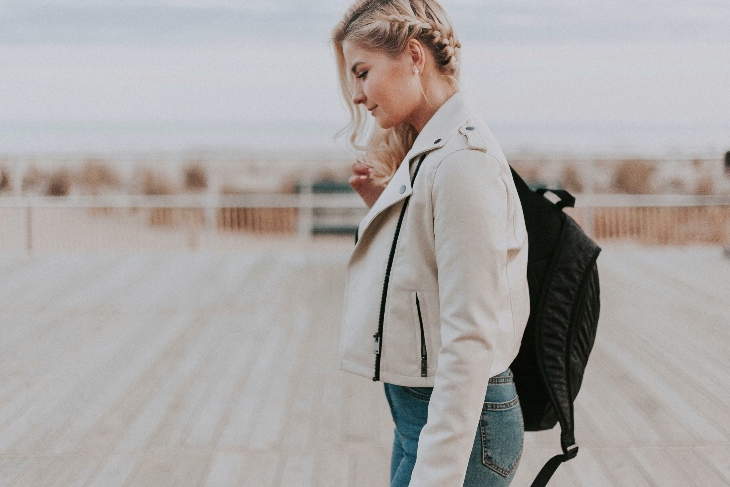 Frau In Schwarzer Reißverschlussjacke Mit Schwarzem Rucksack